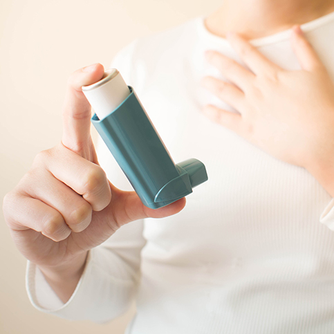 man using puffer to relieve asthma